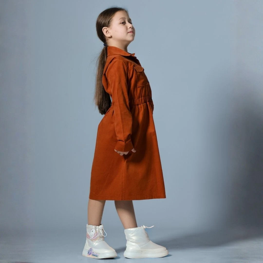 فستان بناتي شتوي ميدي بتصميم قميص عصري، مصنوع من قماش ناعم مع ياقة كلاسيكية وأزرار أمامية كاملة، يتميز بخصر مطاطي وجيوب علوية أنيقة