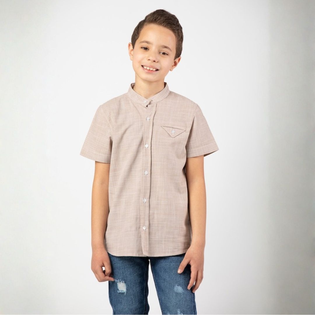 قميص ولادي كاجوال بأكمام قصيرة وياقة ماندارين عصرية، يتميز بخامة قطنية مريحة وجيب أمامي بتصميم هندسي فريد مع زر إغلاق، مثالي للإطلالات الصيفية