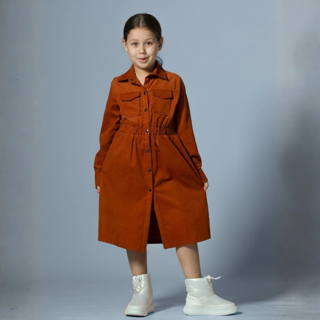 فستان بناتي شتوي ميدي بتصميم قميص عصري، مصنوع من قماش ناعم مع ياقة كلاسيكية وأزرار أمامية كاملة، يتميز بخصر مطاطي وجيوب علوية أنيقة